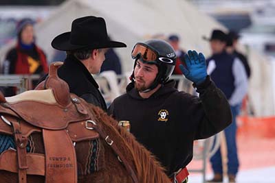 Skijor rider and skier confer